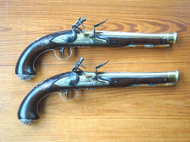 A rare pair of English  Naval Officers' flintlock pistols with brass cannon blunderbuss barrels and silver mounts by William Grice of Birmingham circa 1770